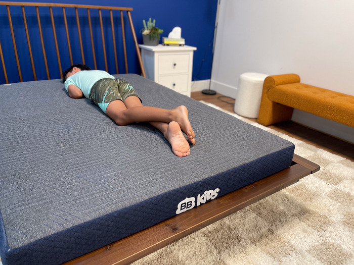 A 10-year-old boy testing out the BB Kids mattress in the stomach-sleeping position.