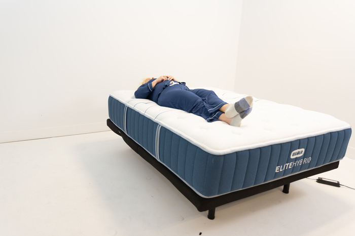 Our tester back-sleeping on a Bear Elite Hybrid mattress