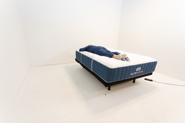 A person is shown stomach sleeping on the Bear Elite Hybrid mattress