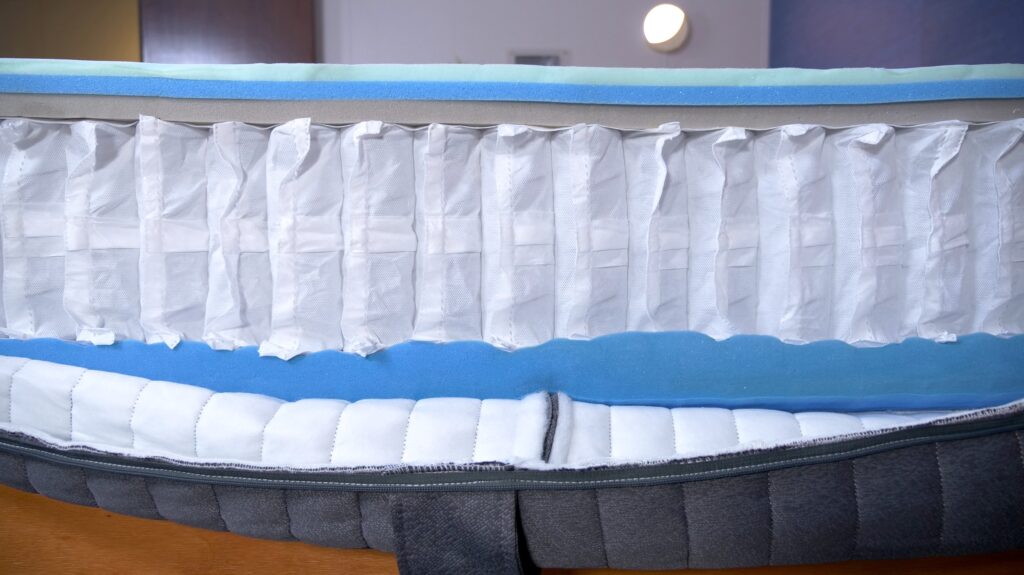 The internal construction of an Emma Hybrid Comfort Mattress is cut open for examination.