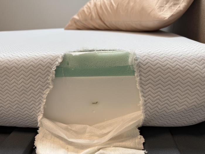 A closeup of the side of the Leesa Kids mattress. The fabric has been cut open to show the foams underneath.
