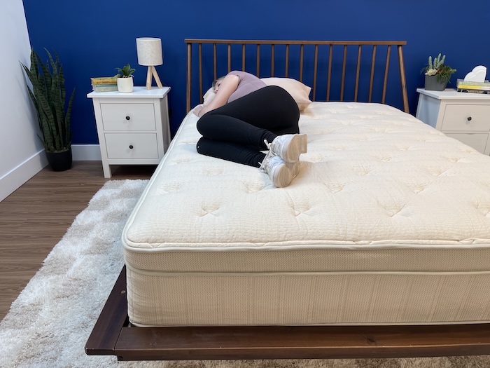 A woman lies on her side on top of the Leesa Natural mattress.