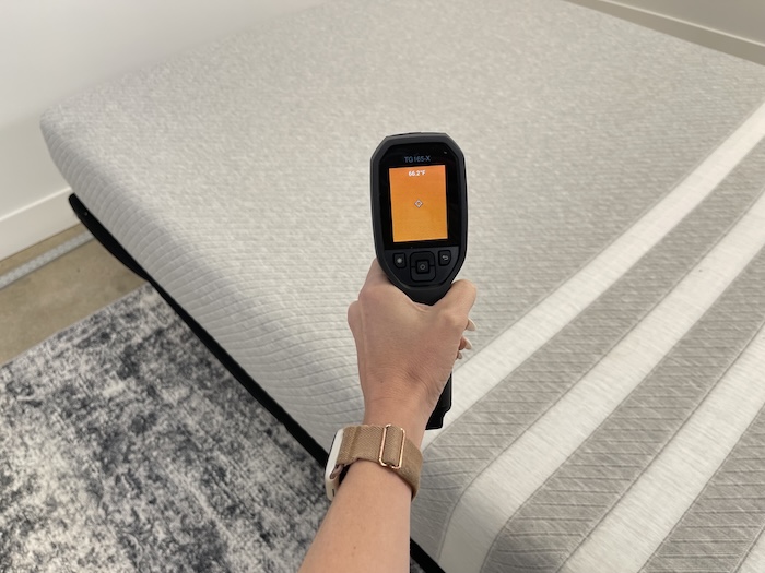 A closeup of someone using a thermal gun to read the neutral temperature of the Leesa Original mattress. The screen reads 66.2 degrees.