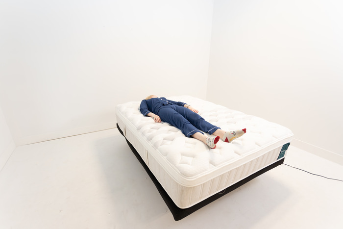 A woman lying on her back on the Leesa Sapira Chill Hybrid mattress.