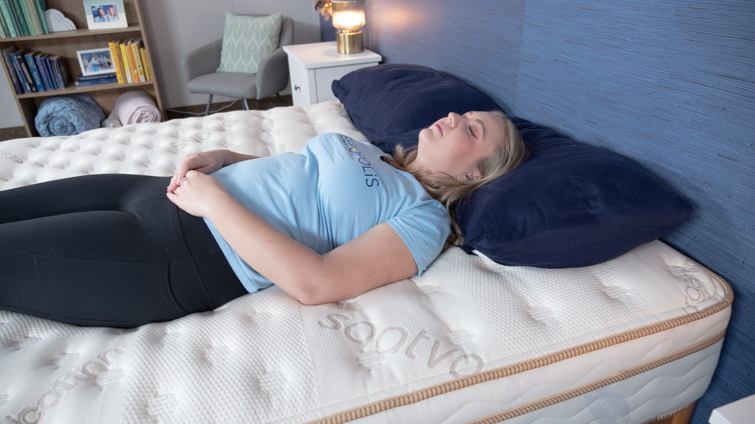 A woman lying on her back on the Saatva mattress.