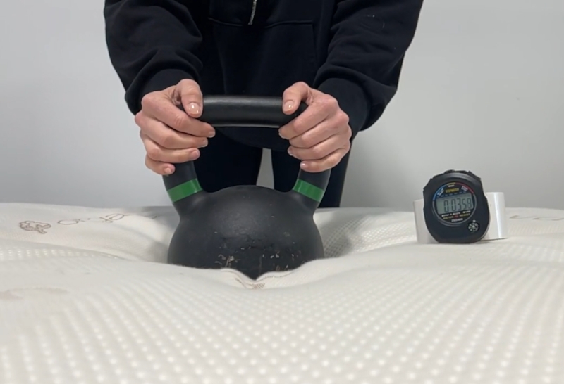 Our expert performing a responsiveness test on a Saatva Latex Hybrid.