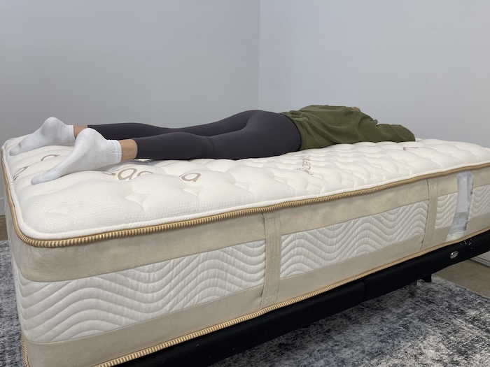 A woman lying on her stomach on the Saatva Rx.