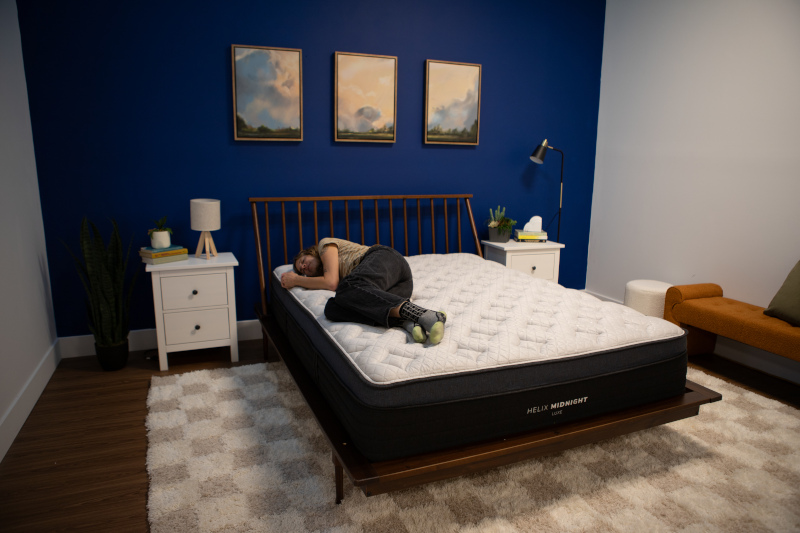 Our tester side-sleeping on a Helix Midnight Luxe Mattress