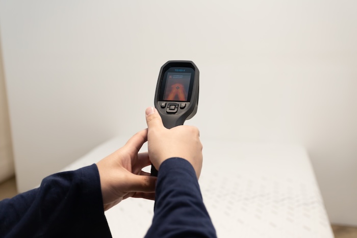 Closeup of someone pointing a thermal gun at the Nectar mattress to read its temperature.