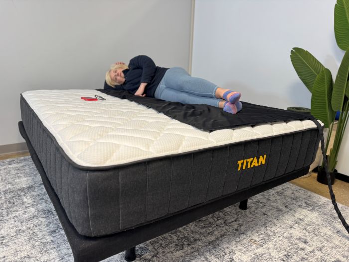 A woman lays on a pressure mat on the Titan Plus mattress