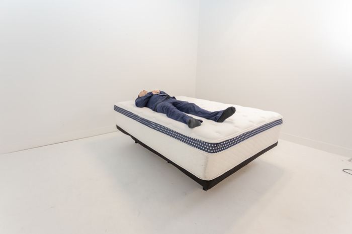 A man lying on his back on the WinkBed Plus mattress.